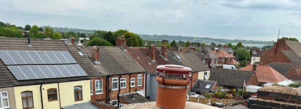 This is a photo taken from a roof which is being repaired, it shows a street of houses, and their roofs